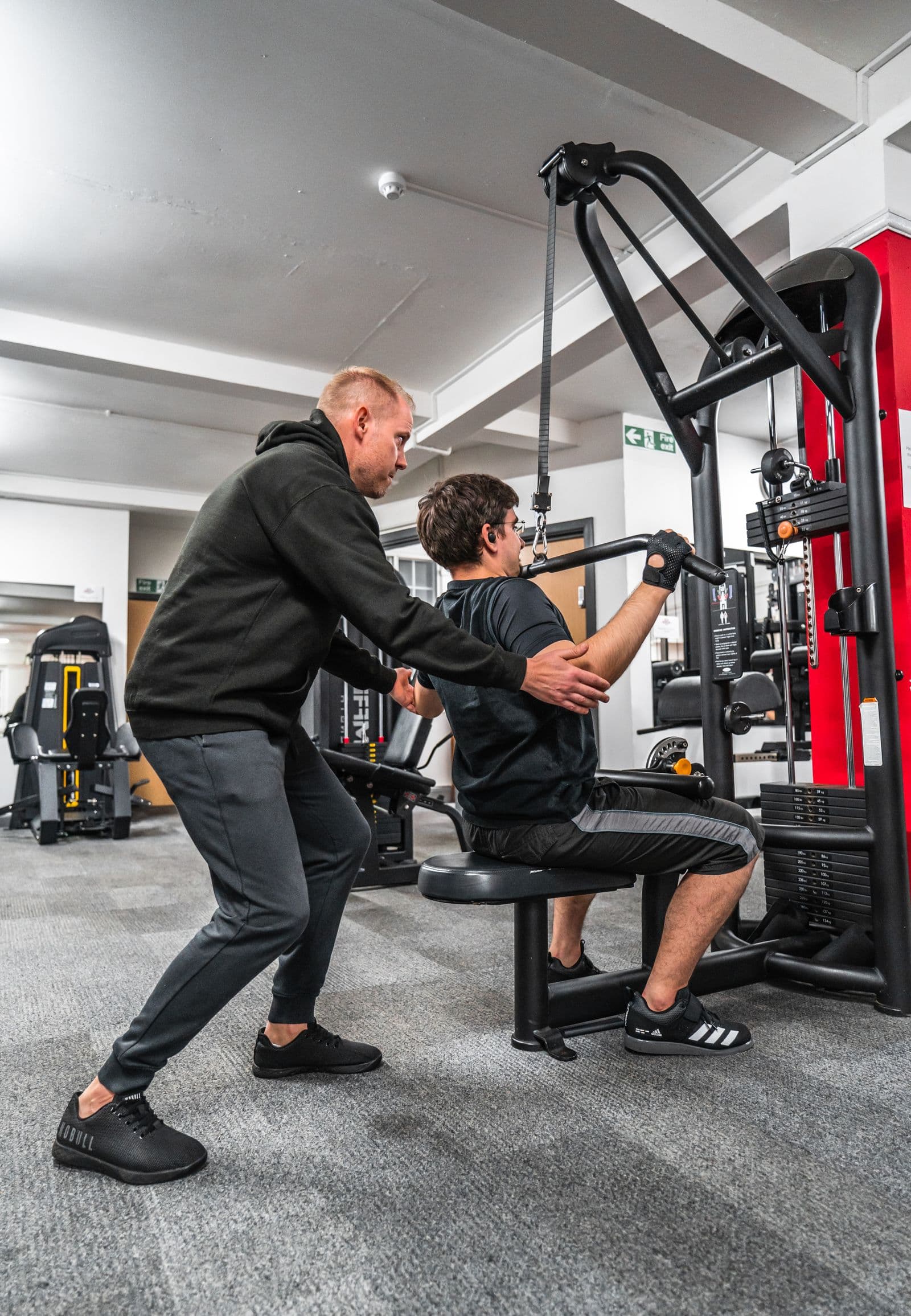 A coach and client reviewing a session plan in the gym